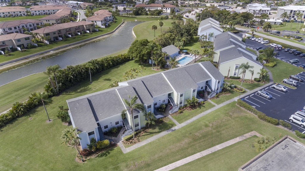 A bird's eye view of a residential area with houses and a parking lot.